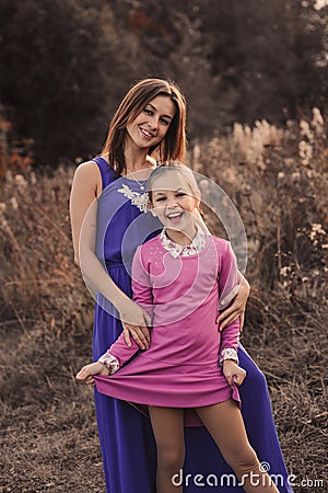 Lifestyle capture of happy mother and preteen daughter having fun outdoor. Loving family spending time together on the walk. Stock Photo