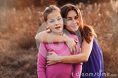 Lifestyle capture of happy mother and preteen daughter having fun outdoor. Loving family spending time together on the walk. Stock Photo