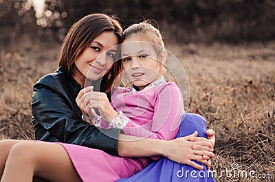 Lifestyle capture of happy mother and preteen daughter having fun outdoor. Loving family spending time together on the walk. Stock Photo