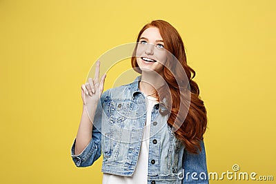 Lifestyle Concept: Happy excited cuacaisan tourist girl pointing finger on copy space on golden yellow Stock Photo