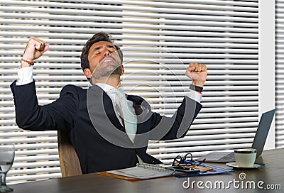 Lifestyle corporate company portrait of young happy and successful business man working excited at modern office sitting by window Stock Photo