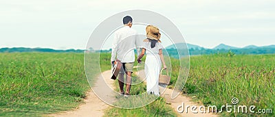 Lifestyle couple picnic sunny time. Asian young couple having fun and walking relax in the meadow Stock Photo