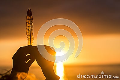 Lifestyle and dreaming hope concept image. Close up of hands holding leaf against a colorful amazing sunset on the ocean. Freedom Stock Photo