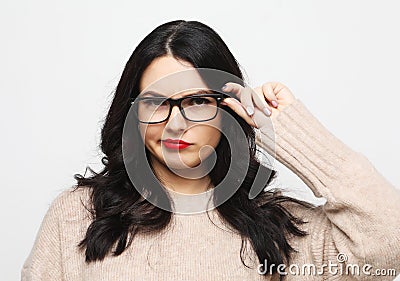 Lifestyle, emotion and people concept - young woman wearing eyeglasses looks incredulously and reflects Stock Photo