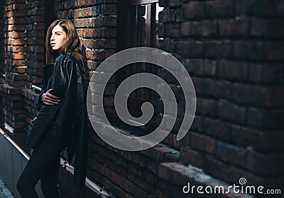 Lifestyle fashion portrait of brunette girl in rock black style, standing outdoors in the city street Stock Photo