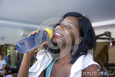 Lifestyle indoors portrait training at gym of young happy and attractive black afro American woman sweaty after hard workout holdi Stock Photo