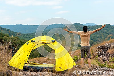 Lifestyle man travel hiker adventure and tent camping on mountain nature landscape. Young people tourist backpack raise hand Stock Photo