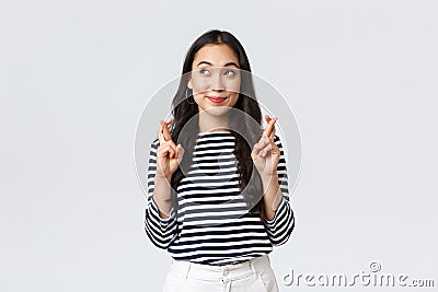 Lifestyle, people emotions and casual concept. Hopeful cute wishful asian girl cross fingers good luck, looking up at Stock Photo