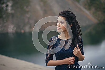 Lifestyle portrait of a woman brunette on the background of the lake in the sand on a cloudy day. Romantic, gentle, mystical Stock Photo