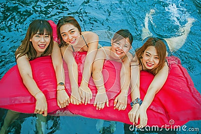 Young Asian Chinese and Korean women group of friends , attractive girlfriends at holidays resort swimming pool having fun in airb Stock Photo