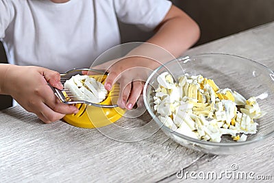 Lifestyle preschooler child girl cook food in the kitchen. development of fine motor skills in everyday life from scrap materials Stock Photo