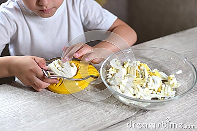 Lifestyle preschooler child girl cook food in the kitchen. development of fine motor skills in everyday life from scrap materials Stock Photo