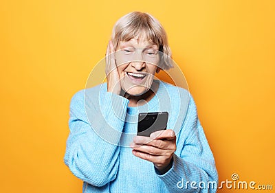 Lifestyle, tehnology and people concept: old granny looks at her smart phone and is surprised Stock Photo