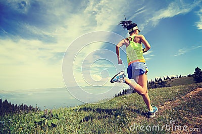 Lifestyle woman trail runner running on mountain peak Stock Photo