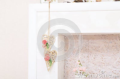 Lifestyle with wooden hearts with white and pink flowers in fireplace for lush interior. home decor. country house decor Stock Photo