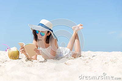 Lifestyle young asian woman relax and reading a book at the beautiful beach on holiday summer, Stock Photo