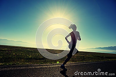 lifestyle young woman runner running on sunrise road Stock Photo