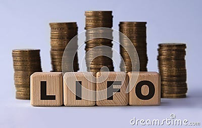 LIFO - acronym on wooden cubes on the background of stacks of coins Stock Photo