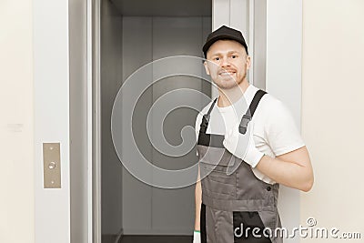 Lift machinist man repairing elevator fixing or adjusting mechanism Stock Photo