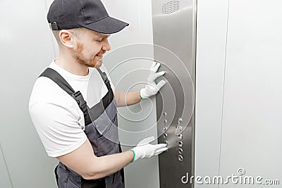 Lift machinist man repairing elevator fixing or adjusting mechanism Stock Photo