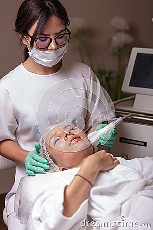 Lifting by ultrasound using a special cosmetology device. Smoothing wrinkles on the face with ultrasound Stock Photo