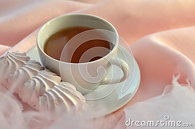 A light and airy composition with a cup of tea and an appetizing marshmallow cake Stock Photo