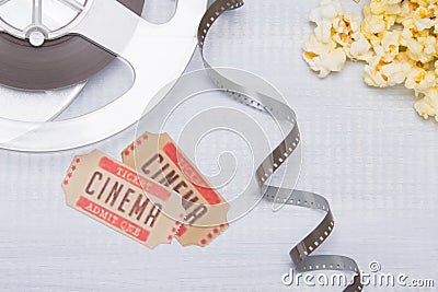 on a light background, unwound film with two tickets to the cinema and fresh popcorn Stock Photo