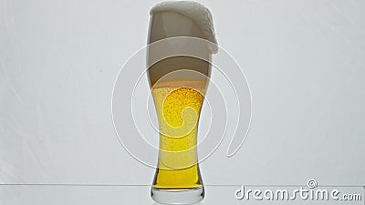 Light beer overflowing glass from glass in super slow motion close up. Hop drink Stock Photo