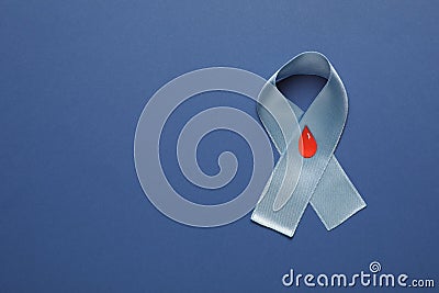 Light blue ribbon with paper blood drop on color background, top view and space for text. Diabetes awareness Stock Photo