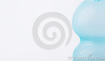 Light blue sweated frosty glass bottle with clear pure cool water on white background. Hydration summer freshness Stock Photo