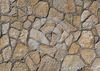 Light brown stone wall made of irregular large flat natural stones with a lot of concrete on the borders. Stock Photo