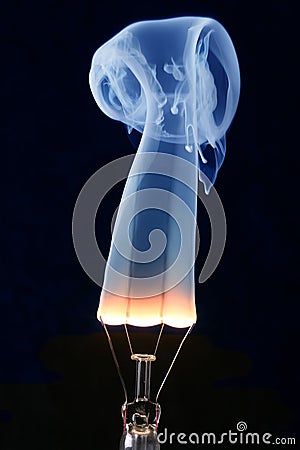 Light bulb and blue smoke on black Stock Photo