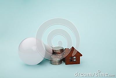 Light bulb with coins stack and house model. Power energy concept Stock Photo