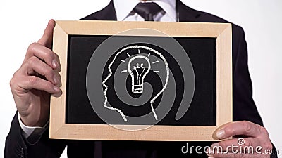 Light bulb head drawn on blackboard in businessman hands, creative business idea Stock Photo
