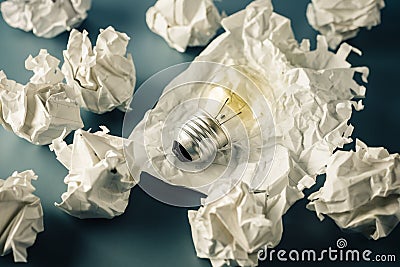 Light Bulb in Trash Paper Stock Photo