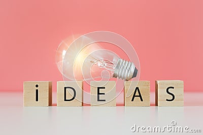 Light bulb on wooden cube blocks with word ideas, thinking creative genius innovation knowledge successful. Stock Photo