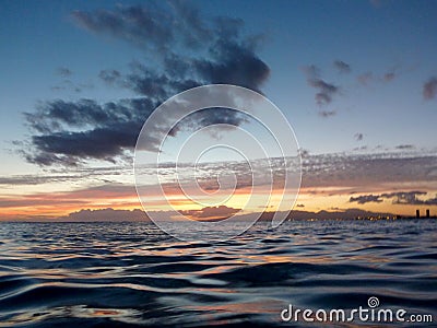 Light of Dusk illuminate the shallow ocean waters of Waikiki Stock Photo