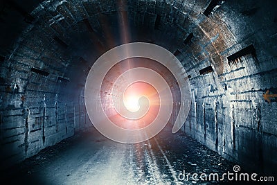 Light in end of tunnel. Long underground concrete corridor in abandoned bunker Stock Photo