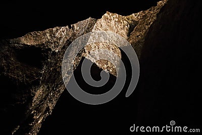 LIGHT ENTERING AN OPENING IN THE ROOF OF A CAVE Stock Photo