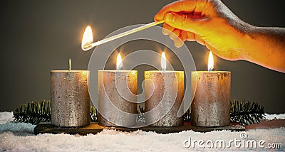 Light four advents candles with matches Stock Photo