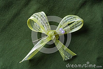 Light-green bow with two white pins and darkgreen background. Handmade concept - Image Stock Photo