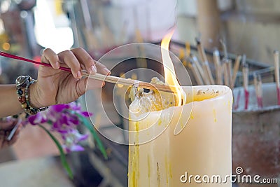 Light incense on a large candle to worship the god of Buddhism Stock Photo