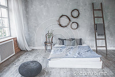 Light loft style bedroom interior,design made in gray and purple colors with modern furniture,big windows,ladder near white bed. Stock Photo