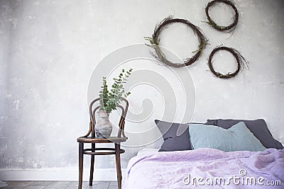 Light loft style bedroom interior,design made in gray and purple colors with modern furniture,close up of bed and vase on chair Stock Photo