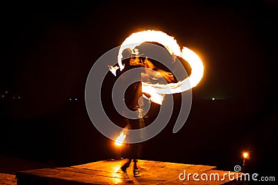 Street artist fire juggling performance. Light painting and long exposure picture to form trails. Phi Phi Island, Thailand. Editorial Stock Photo