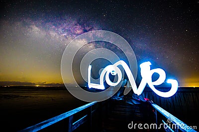 Light painting the LOVE word and milky way Stock Photo