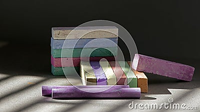 On a dark background, bright, colored crayons.Rainbow colorful chalk pastel for preschool children.Light pattern on the compositio Stock Photo