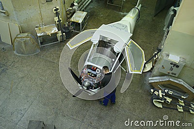 Light planes assembly hall, worker assembling passenger plane Editorial Stock Photo