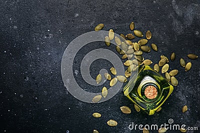 Light pumpkin seeds oil in glass jar on gray kitchen table background, top view Stock Photo