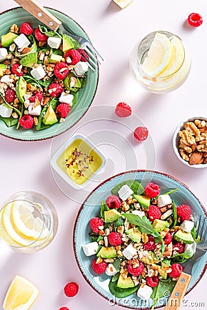 Light salad with raspberry, baby spinach, feta cheese, avocado and walnuts, top view. Fresh original summer salad with Stock Photo